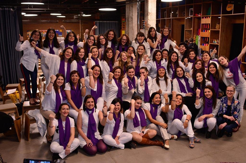 A cohort of women innovators with purple scarves
